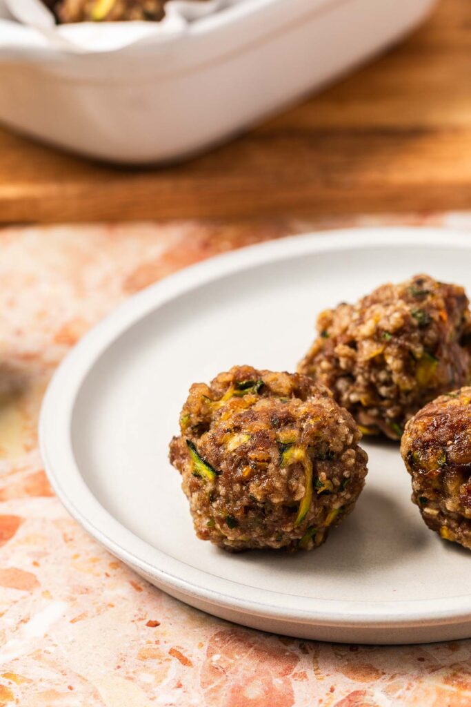 three baked zucchini meatballs on a plate