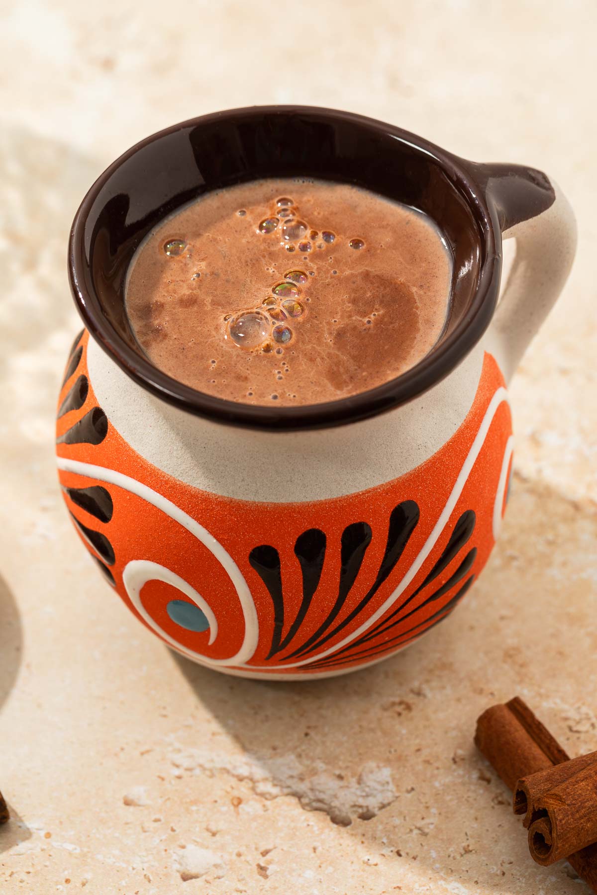 Mexican Champurrado ready to be served with cinnamon sticks peaking into frame