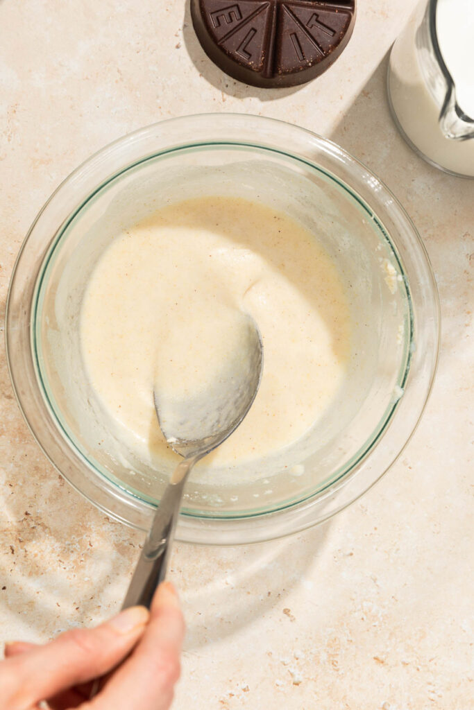 masa-harina being dissolved in a small glass bowl with water for Mexican champurrado