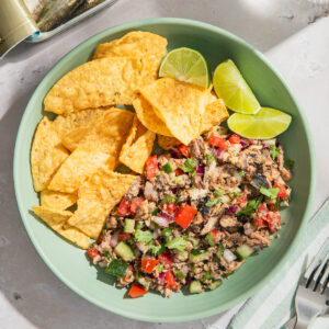 sardines ceviche served with tortilla chips and lime wedges